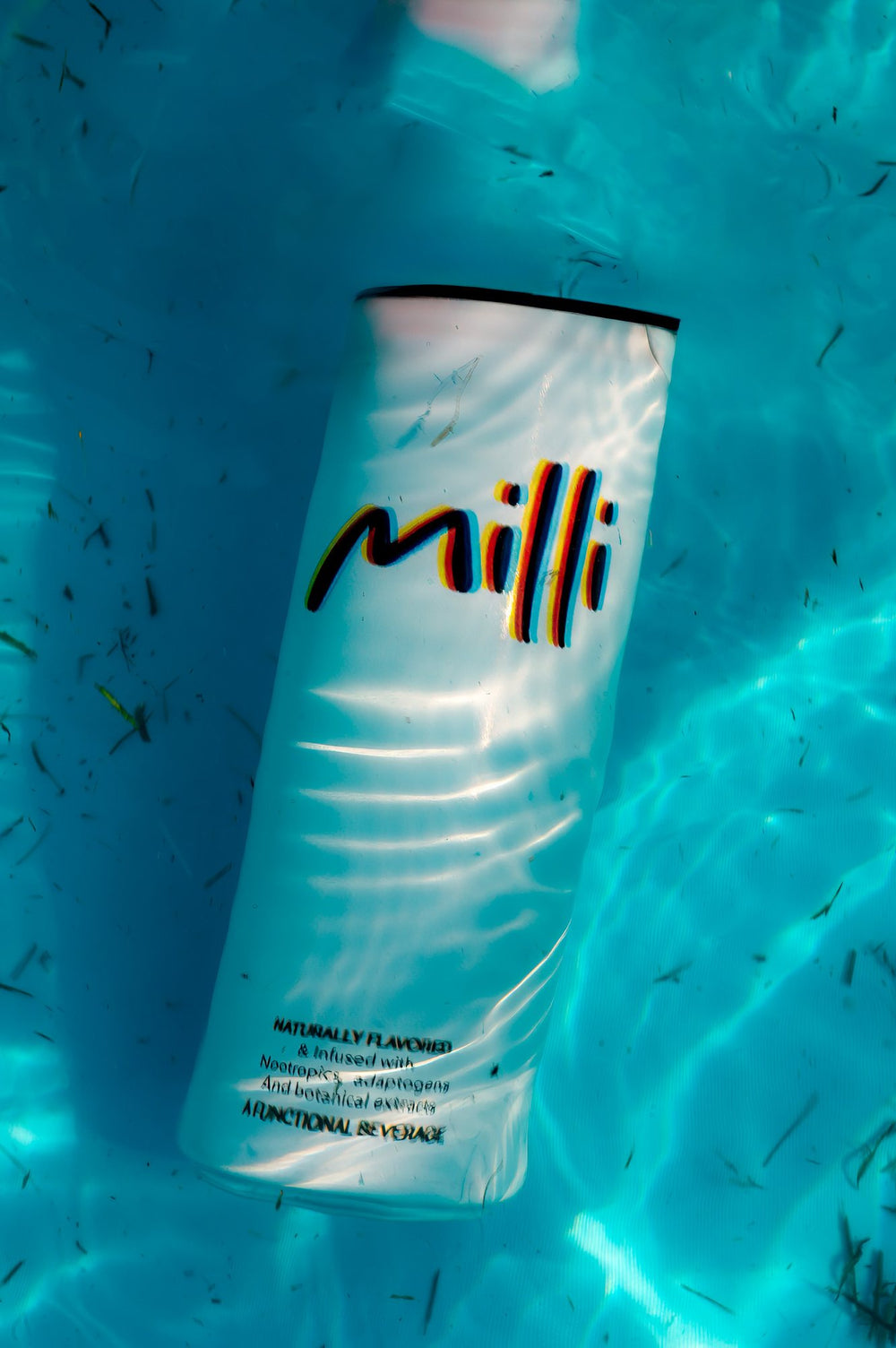 A can of Milli floating in a bright turquoise pool
